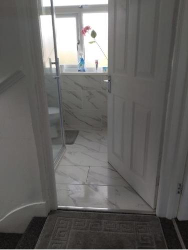 an open door to a bathroom with a tile floor at Fresher Space Home Stay in Birmingham