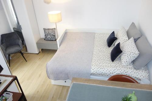 een slaapkamer met een bed met kussens en een stoel bij City Centre Samobor in Samobor