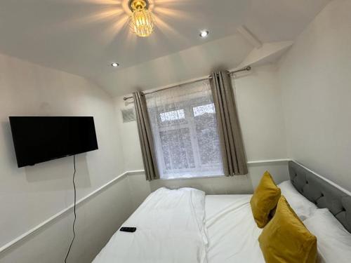 ブロムリーにあるCosy Smart/Small Double Room in Keedonwood Road Bromleyのベッドルーム(ベッド1台、薄型テレビ付)