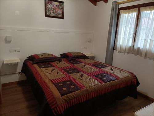 a bed in a bedroom with a blanket on it at Casa de Santa Luzia A in Vila Praia de Âncora