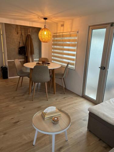 - un salon avec une table, des chaises et un canapé dans l'établissement Chalet Quattro in bosrijke omgeving, à Anloo