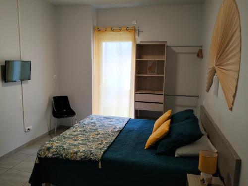 a bedroom with a bed with blue sheets and a window at Tikazéla - Escale Tournon-Sur-Rhône in Tournon-sur-Rhône