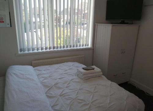 a white bed in a room with a window at Fresher Space Home Stay in Birmingham