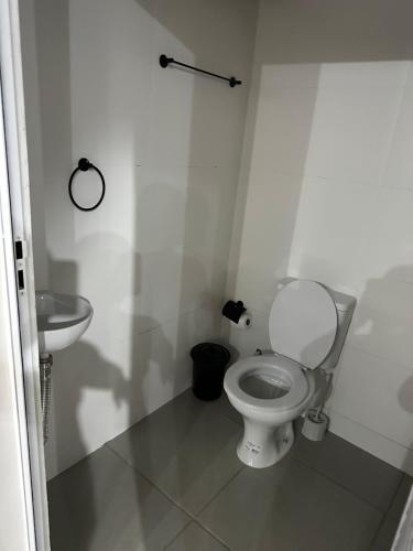 a white bathroom with a toilet and a sink at Área de Lazer morada do sol in Sao Jose do Rio Preto