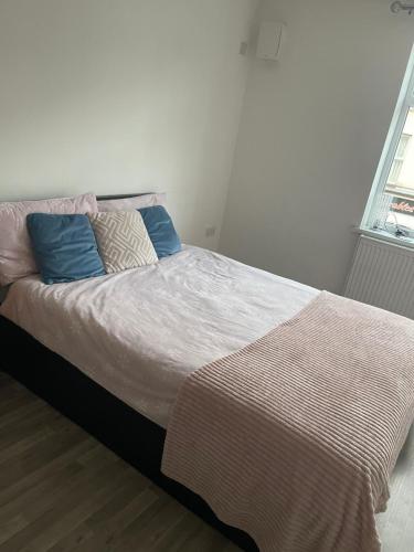 a bedroom with a large bed with blue pillows at EG premier lodge in Gillingham