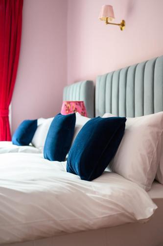 a bed with blue and white pillows on it at Queen Charlotte Guesthouse in Edinburgh