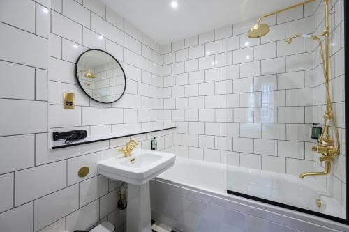 a white bathroom with a sink and a tub at Queen Charlotte Guesthouse in Edinburgh