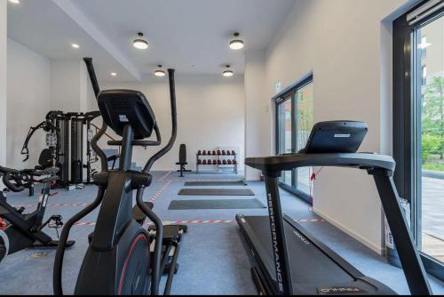 a gym with two exercise bikes and a treadmill at Living Berlin in Berlin