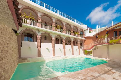 a swimming pool in the courtyard of a building at Hotel San Juan in Puerto Escondido