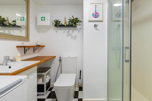 La salle de bains est pourvue de toilettes et d'une douche en verre. dans l'établissement Cozy beach studio retreat near Lisbon with Sea View, à Almada