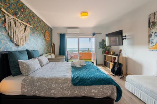 um quarto com uma cama e vista para o oceano em Cozy beach studio retreat near Lisbon with Sea View em Almada
