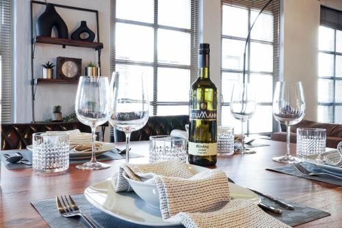 a bottle of wine sitting on a table with glasses at nobilis Apartment - 7 Pers - Marktplatz - Netflix - PS4 in Lingen