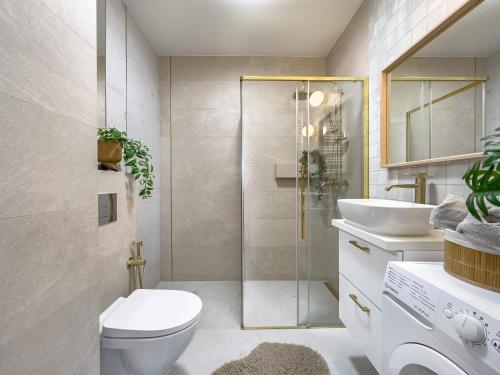 uma casa de banho com um chuveiro, um WC e um lavatório. em Krakowska Oaza Komfortu - Apartament Premium z Garażem em Cracóvia