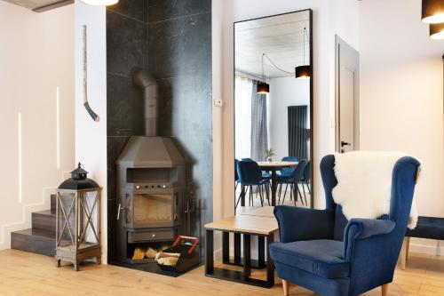 a living room with a chair and a wood stove at Aroma Domki - Krynica Zdrój in Krynica Zdrój