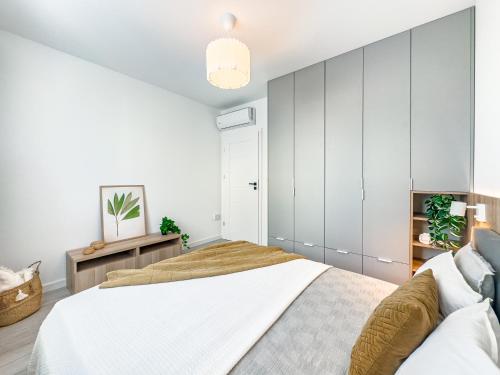 um quarto com paredes brancas e uma cama grande em Krakowska Oaza Komfortu - Apartament Premium z Garażem em Cracóvia