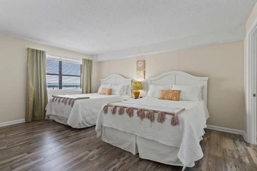 a bedroom with two beds and a window at Oceans At The Grove By Hostique in Myrtle Beach