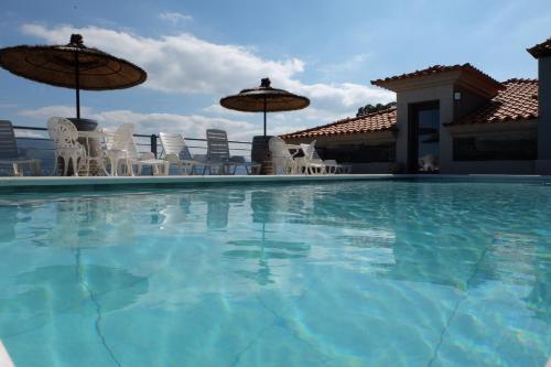 a large swimming pool with chairs and umbrellas at Quinta da Bandeira - Casa de Férias no Douro in Mártir