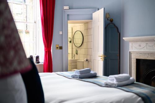 a bedroom with a bed with towels on top of it at Queen Charlotte Guesthouse in Edinburgh