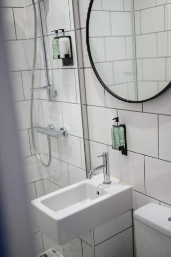 a bathroom with a sink and a mirror and a toilet at Queen Charlotte Guesthouse in Edinburgh