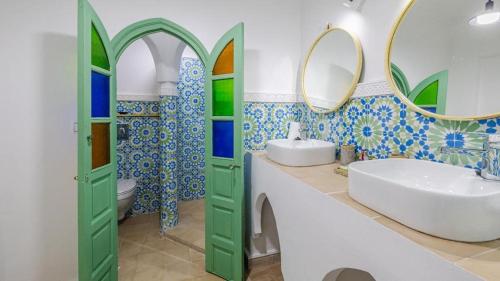 uma casa de banho com um lavatório e um espelho em riad asmaa em Marrakech