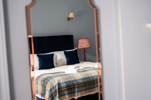 a bedroom with a four poster bed with a lamp at Queen Charlotte Guesthouse in Edinburgh