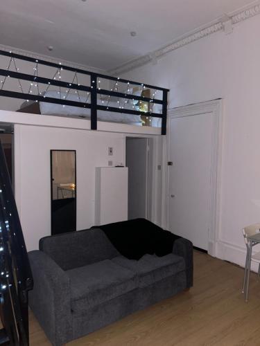 a living room with a couch and a loft bed at Alexander Greek Thomson Apartment in Glasgow