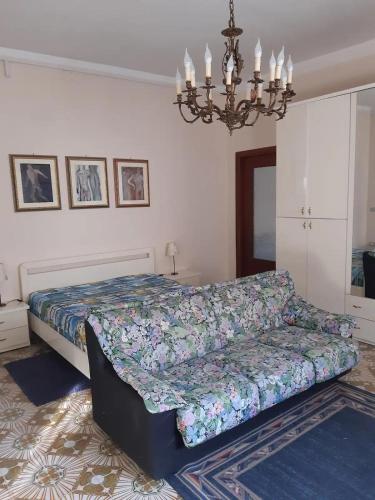 ein Schlafzimmer mit einem Bett und einem Sofa in der Unterkunft Camera matrimoniale accogliente in Caserta