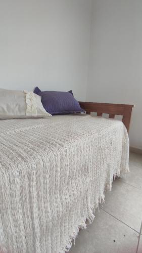 uma cama com um cobertor branco em cima em Alamos David em Villaguay