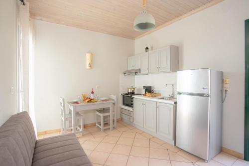 Una cocina con refrigerador de acero inoxidable y una mesa. en Romanza Studios, en Vasiliki