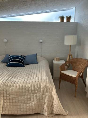 um quarto com uma cama, uma cadeira e um candeeiro em GuestHouse Læsø em Vesterø Havn