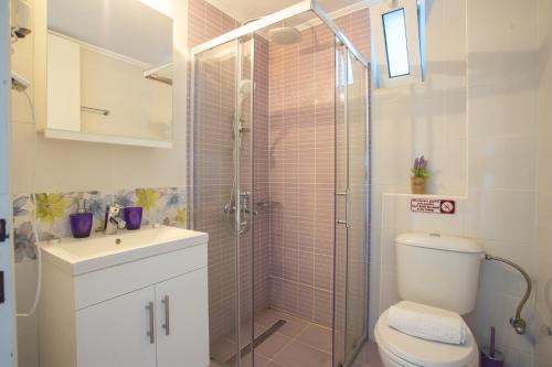 Un baño con ducha, inodoro y lavabo. en Romanza Studios, en Vasiliki