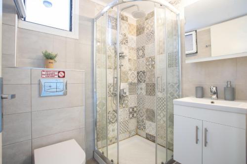 a bathroom with a shower and a toilet and a sink at Romanza Studios in Vasiliki