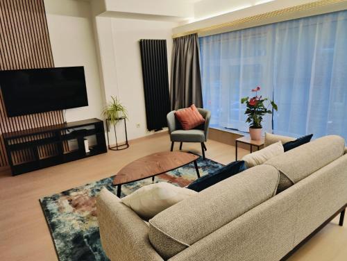 a living room with a couch and a flat screen tv at Bright & Cozy Appartment in Brussels in Brussels