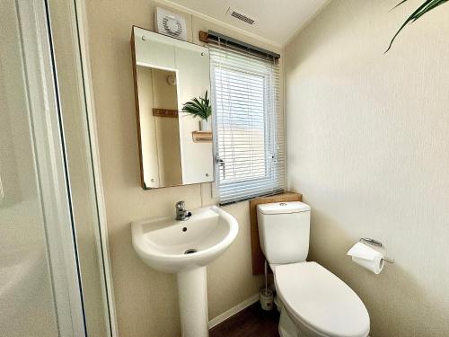 a bathroom with a sink and a toilet and a mirror at Haven Seashore Holiday Park in Caister-on-Sea