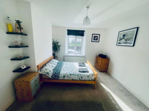 a bedroom with a bed and a window at Ground floor entire costal apartment in Watchet. in Watchet