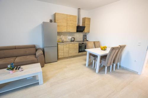a living room with a table and a kitchen at Apartmani Lauc in Ljubuški