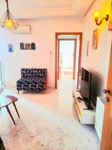 a living room with a couch and a tv at Les jardins du lac 2 in Tunis