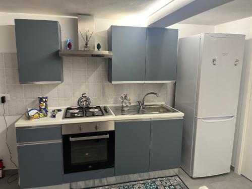 a kitchen with a sink and a refrigerator at Mandorlo Barocco in Noto