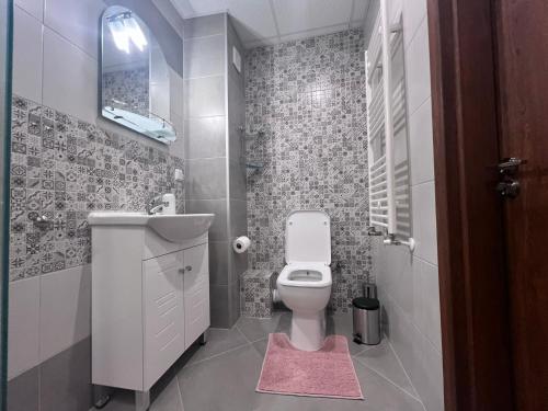 a small bathroom with a toilet and a sink at Cappuccino apartment in Sofia