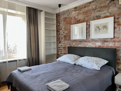 una camera da letto con un muro di mattoni e un letto con cuscini di Modern Flat In The Centre - by HIK Apartments a Varsavia