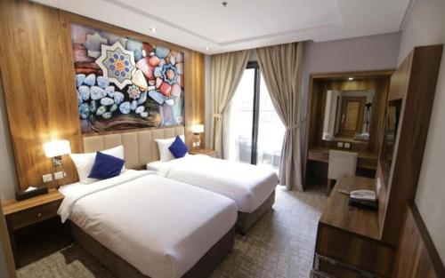 a hotel room with two beds and a painting on the wall at EWG Golden Sea Hotel Obhur in Jeddah