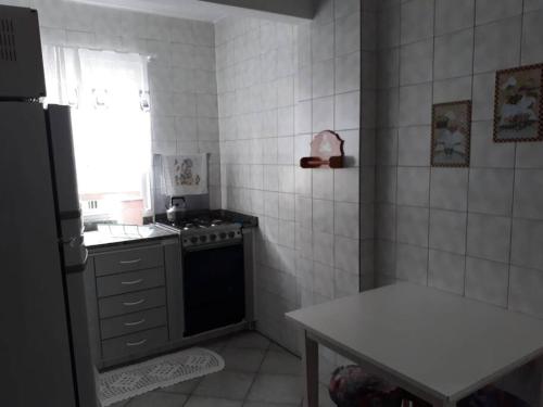 y cocina con fogones, fregadero y nevera. en Apartamento na Avenida Atlântica, en Balneário Camboriú