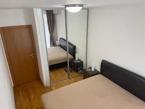 een kleine kamer met een bed en een spiegel bij Apartament L Blue Horizont Przno in Budva