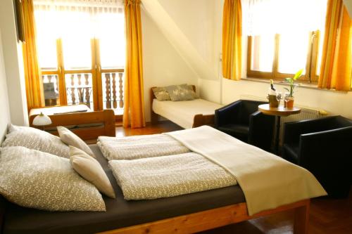 um quarto com uma cama, um sofá e janelas em CHATA MANIOWY Wyspa Ciszy nieopodal Czorsztyna, Maniowy i Kluszkowce nad Zalewem Czorsztynskim em Maniowy