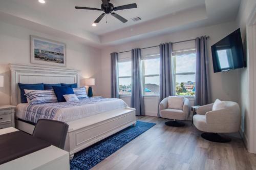 a bedroom with a bed and a tv and a chair at Galveston Beach House w Water Views & New Pool in Galveston