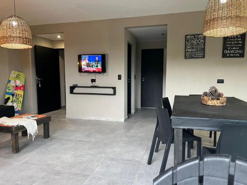 a dining room with a table and chairs and a tv at OCEANO a dos cuadras de la playa in Las Gaviotas