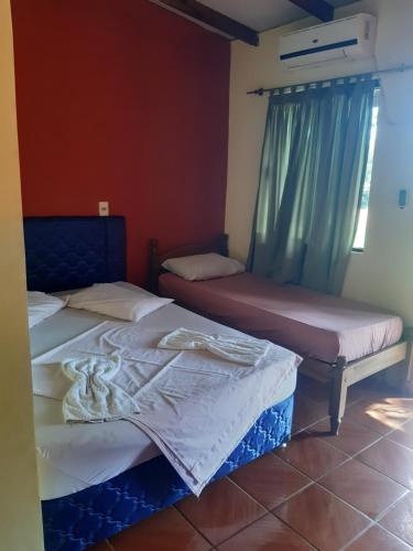 dos camas sentadas una al lado de la otra en una habitación en Hotel-Balneario Acuamanía en Hernandarias