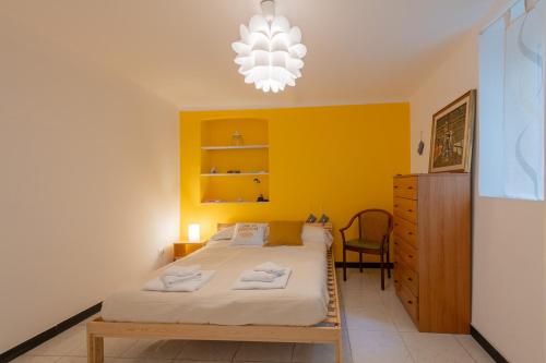 a bedroom with a bed and a yellow wall at Appartamento San Rocchino 37 - Affitti Brevi Italia in Genova