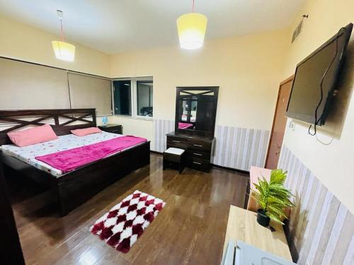 1 dormitorio con 1 cama grande y TV en Master Sea view Room Attached Washroom, en Dubái
