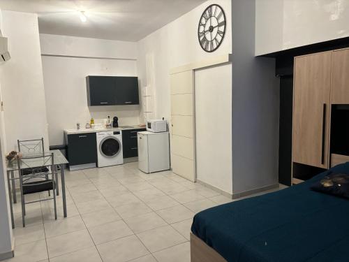 a room with a bed and a kitchen with a tv at Rue BARRAT in Cayenne